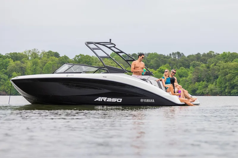 Slide: The Image of Manufacturer Provided Image: 2026 Yamaha Boats AR250 on a lake with people relaxing onboard. - 3