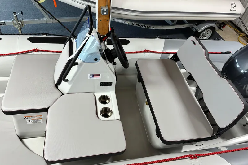Slide: The Image of 2026 Zodiac Open 4.8 boat interior with seating and steering console. - 6