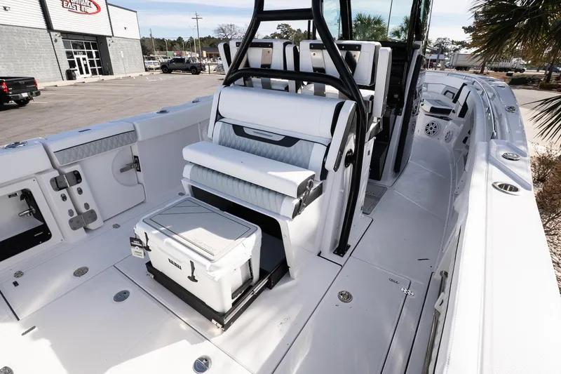 Slide: The Image of 2026 Blackfin 302 CC boat interior with seating and storage, parked outdoors. - 13