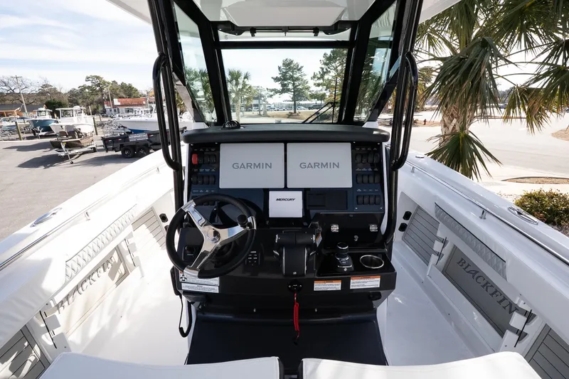 Slide: The Image of 2026 Blackfin 302 CC boat cockpit with Garmin navigation system and Mercury controls. - 16