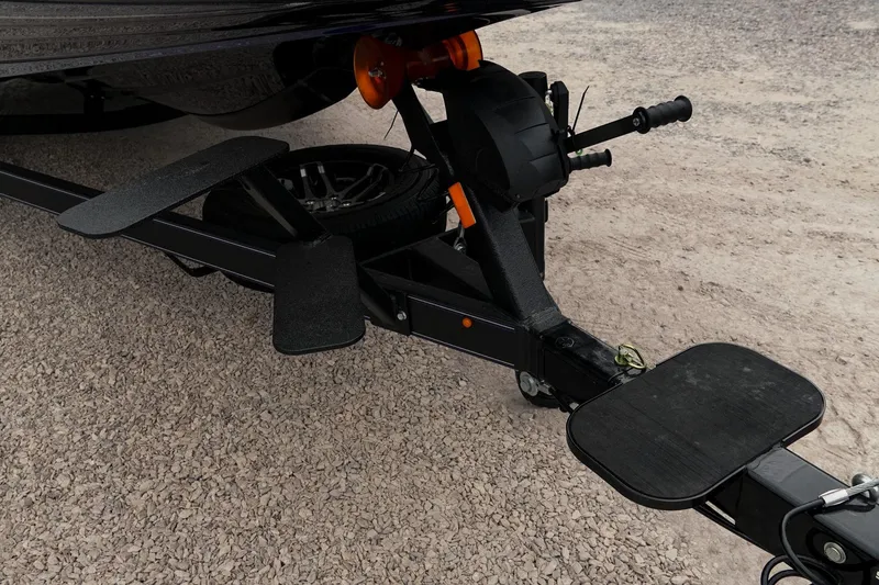 Slide: The Image of 2024 Skeeter ZXR20 boat trailer hitch and step on gravel surface. - 20