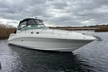 Slide: The Image of 2005 Sea Ray 340 Sundancer boat on calm water under cloudy skies. - 1