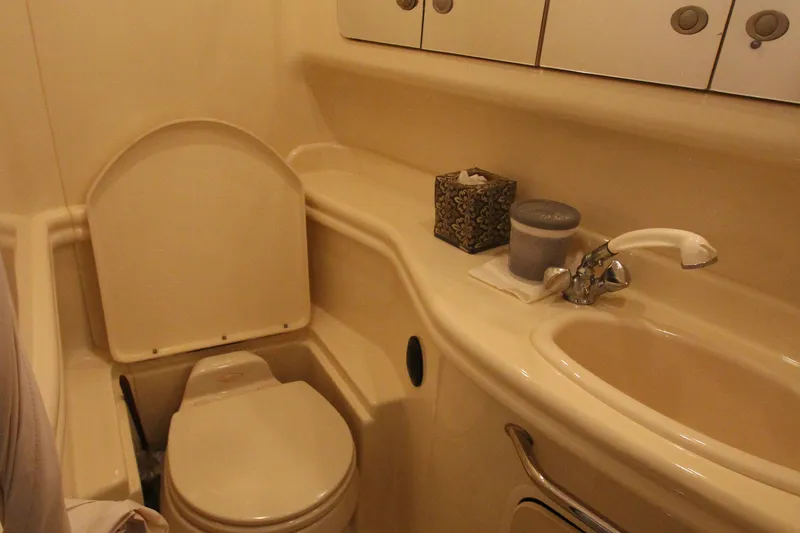 Slide: The Image of 2005 Sea Ray 340 Sundancer bathroom with toilet, sink, and storage cabinets. - 18