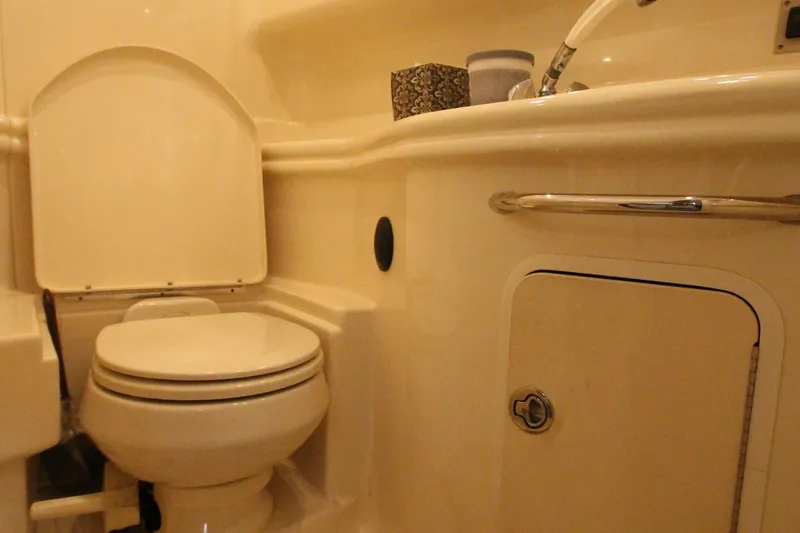 Slide: The Image of 2005 Sea Ray 340 Sundancer bathroom with toilet, sink, and storage compartment. - 19