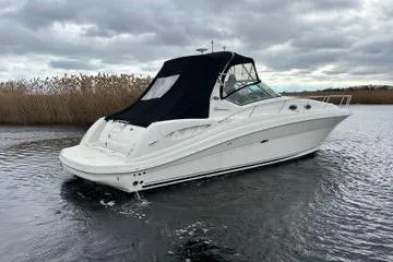 Slide: The Image of 2005 Sea Ray 340 Sundancer boat on a calm waterway under cloudy skies. - 2