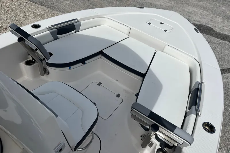 Slide: The Image of 2024 Robalo 226 Cayman boat interior with cushioned seating and storage compartments. - 13