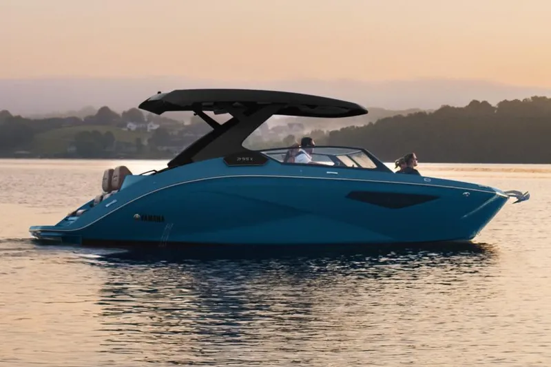 Slide: The Image of Manufacturer Provided Image: 2026 Yamaha Boats 295XD cruising on a serene lake at sunset. - 2