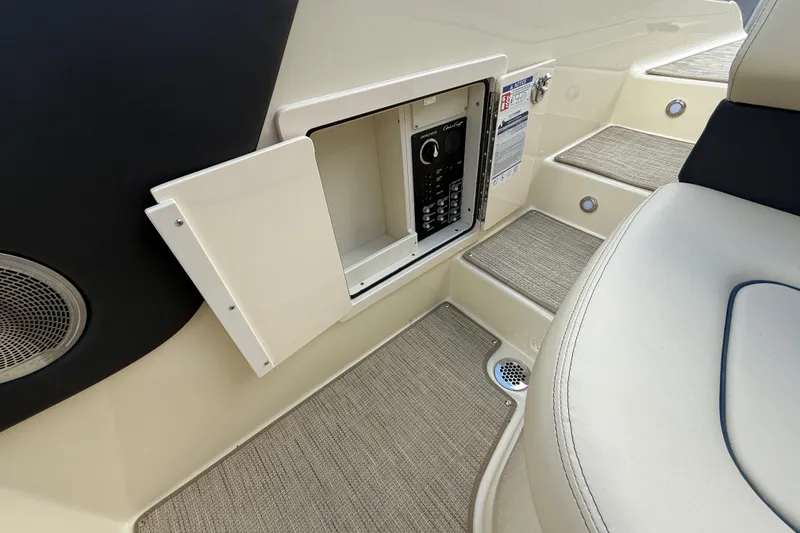 Slide: The Image of 2026 Chris-Craft Sportster 28 interior with open storage compartment and control panel. - 14