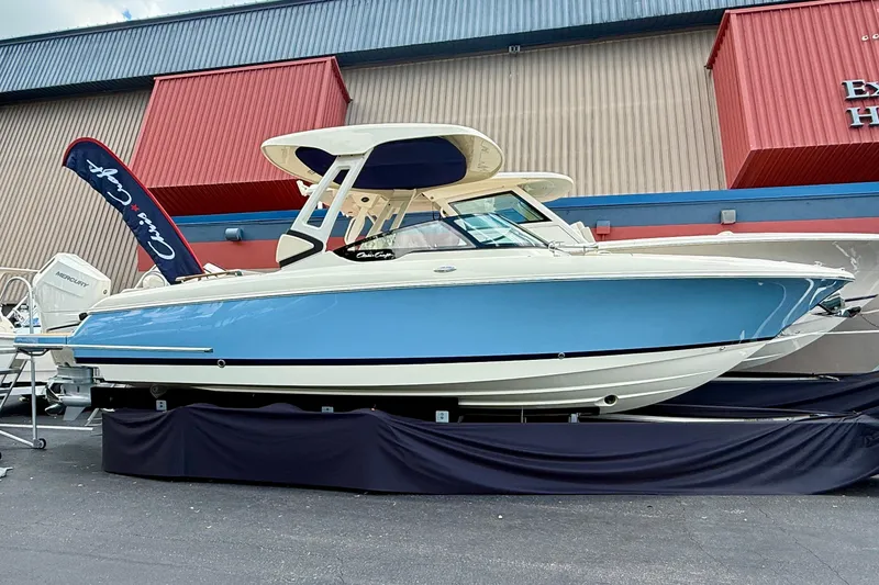 The Image of 2026 Chris-Craft Sportster 28 boat displayed outdoors, featuring a sleek blue and white design. - 52