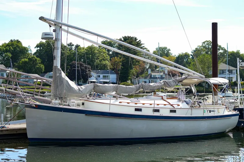 Slide: The Image of 1988 Nonsuch 30 Ultra sailboat docked in a serene marina setting. - 0