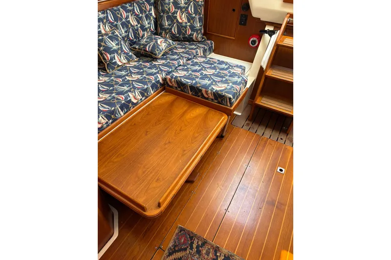 Slide: The Image of Interior of 1988 Nonsuch 30 Ultra sailboat with patterned cushions and wooden table. - 11