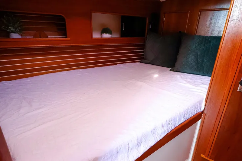 Slide: The Image of Cozy cabin interior of 1988 Nonsuch 30 Ultra sailboat with wooden finish and bedding. - 15