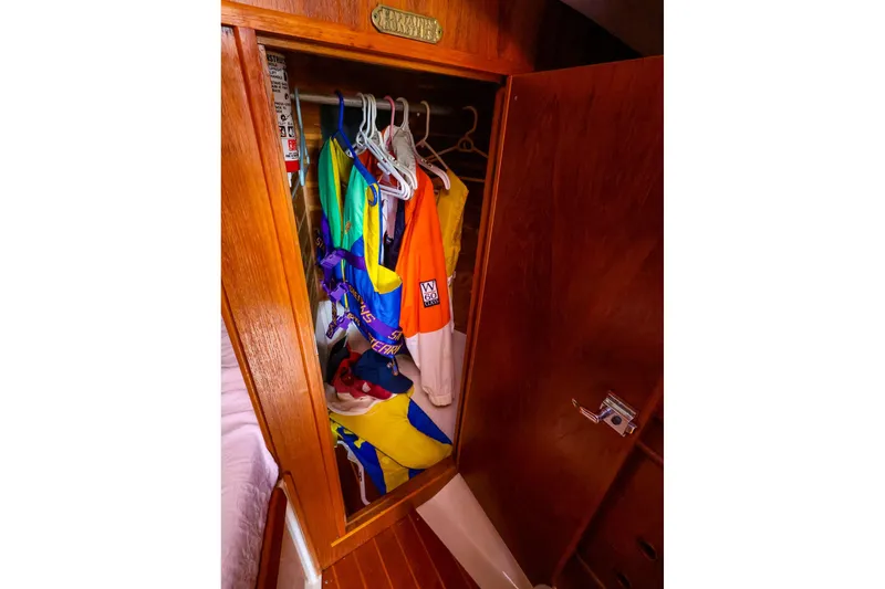 Slide: The Image of Wooden closet with colorful clothes inside a 1988 Nonsuch 30 Ultra sailboat. - 17