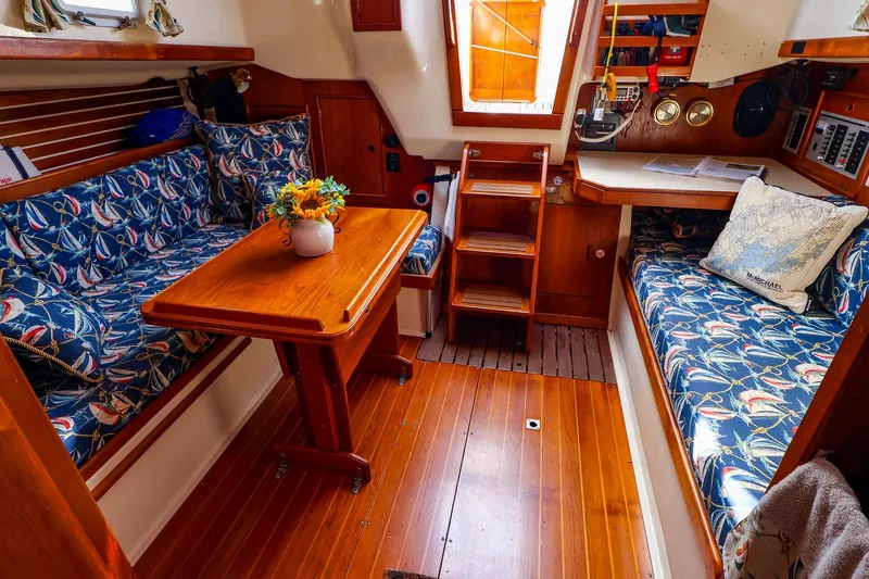 Slide: The Image of Cozy interior of 1988 Nonsuch 30 Ultra sailboat with nautical-themed upholstery and wooden furnishings. - 5