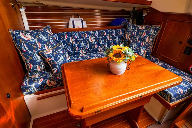 Slide: The Image of Cozy 1988 Nonsuch 30 Ultra cabin with nautical cushions and wooden table. - 7