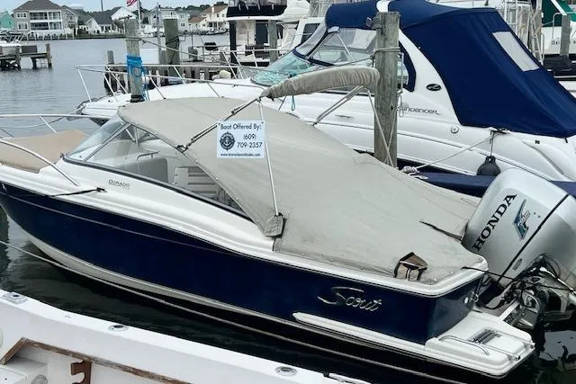 The Image of 2008 Scout 242 Dorado boat docked, covered, with Honda outboard motor. - 0