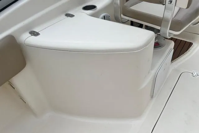 Slide: The Image of 2008 Scout 242 Dorado boat interior, featuring a white seating area and storage compartment. - 17