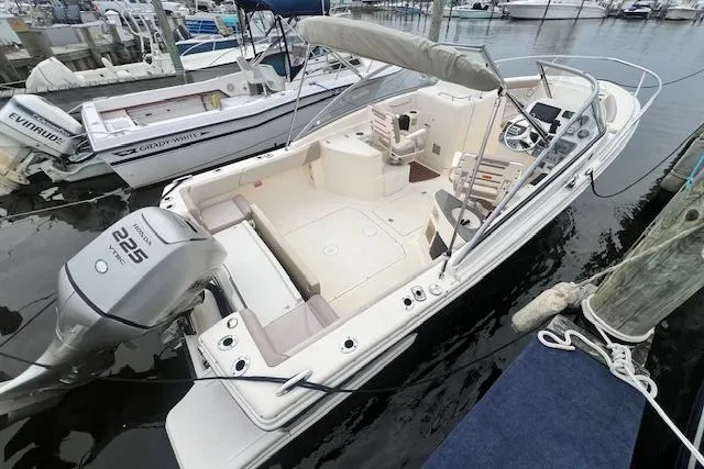 Slide: The Image of 2008 Scout 242 Dorado boat docked, featuring spacious seating and a powerful 225 engine. - 2