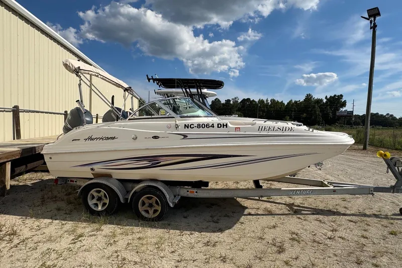 The Image of 2008 Hurricane SunDeck 195 OB boat on trailer, parked outdoors under a blue sky. - 0