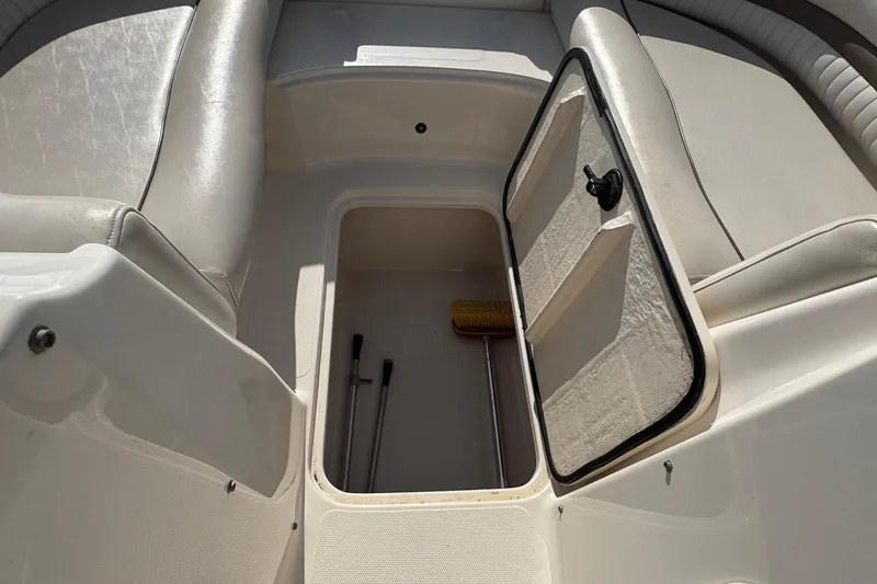 Slide: The Image of 2008 Hurricane SunDeck 195 OB boat storage compartment with open hatch and cleaning tools. - 14