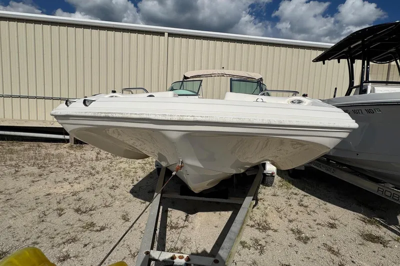 Slide: The Image of 2008 Hurricane SunDeck 195 OB boat on trailer, parked outdoors under cloudy sky. - 2