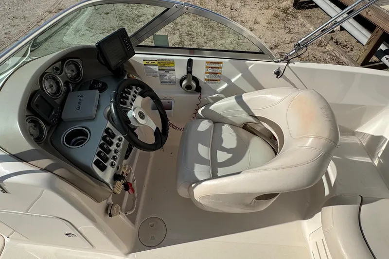 Slide: The Image of 2008 Hurricane SunDeck 195 OB boat cockpit with steering wheel, gauges, and white captain's chair. - 8