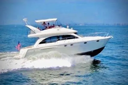 The Image of 2004 Meridian 411 yacht cruising on open water under clear blue skies. - 1