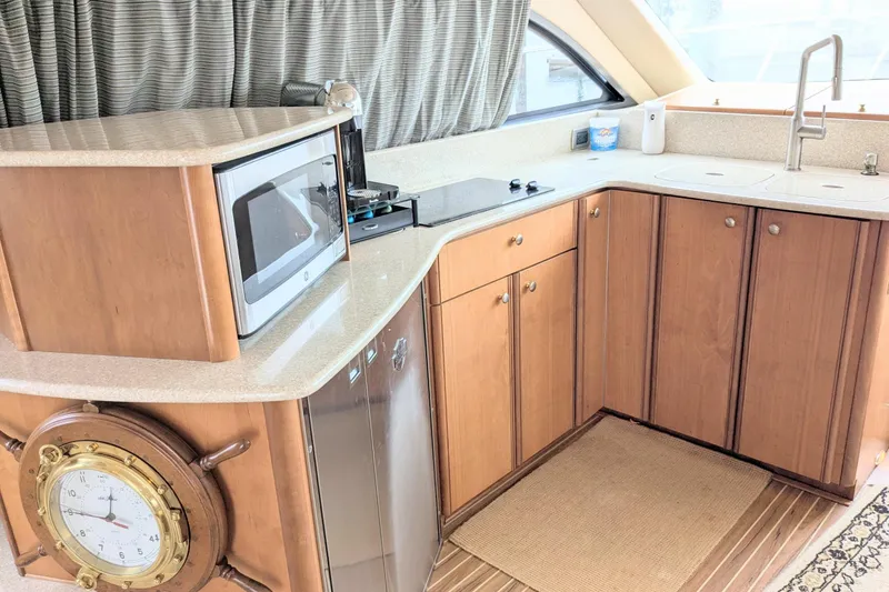 Slide: The Image of 2004 Meridian 411 yacht kitchen with microwave, stove, and wooden cabinets. - 18