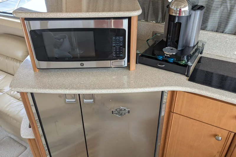 Slide: The Image of 2004 Meridian 411 yacht kitchen with microwave, coffee maker, and Harley-Davidson fridge. - 19