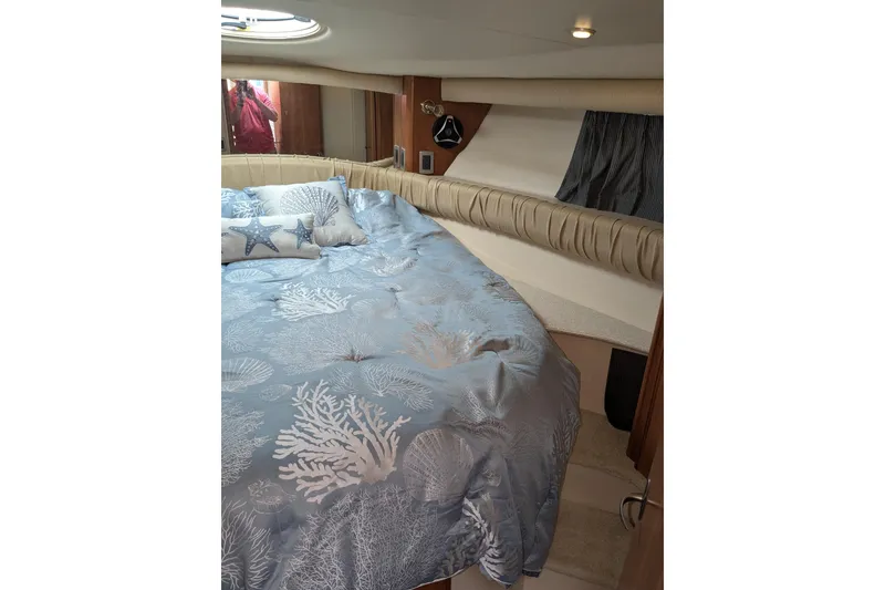 Slide: The Image of Luxurious 2004 Meridian 411 yacht bedroom with nautical-themed bedding and elegant decor. - 21