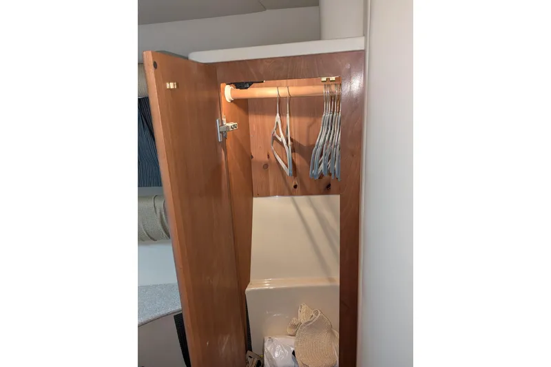 Slide: The Image of Wooden closet interior with hangers in a 2004 Meridian 411 boat. - 23