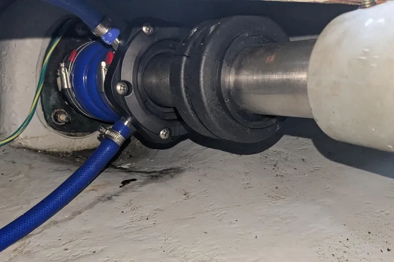 Slide: The Image of Close-up of a 2004 Meridian 411 boat's shaft seal with blue hose and metal fittings. - 33