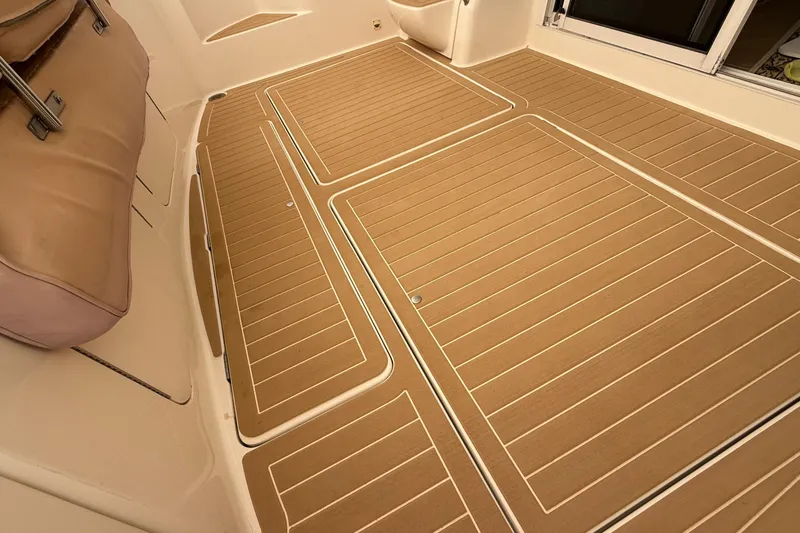 Slide: The Image of 2004 Meridian 411 boat deck with tan marine flooring and cushioned seating. - 41