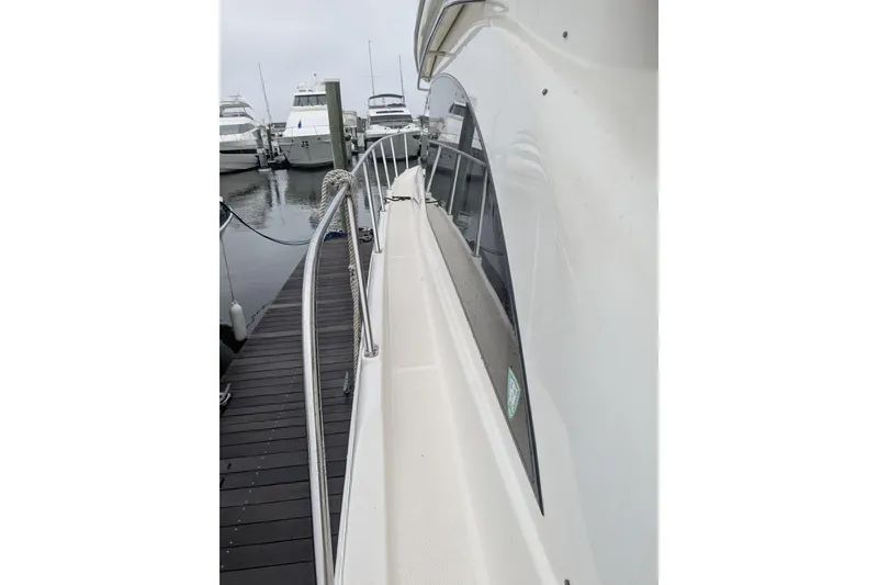 Slide: The Image of 2004 Meridian 411 yacht docked, showcasing sleek side view and railing. - 6