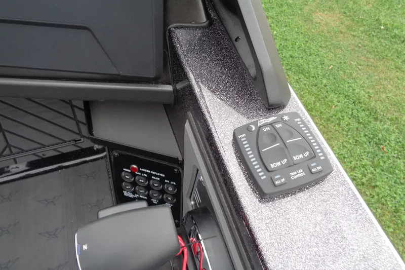 Slide: The Image of 2026 Vexus DVX22S boat control panel with trim tab controls and switches. - 16