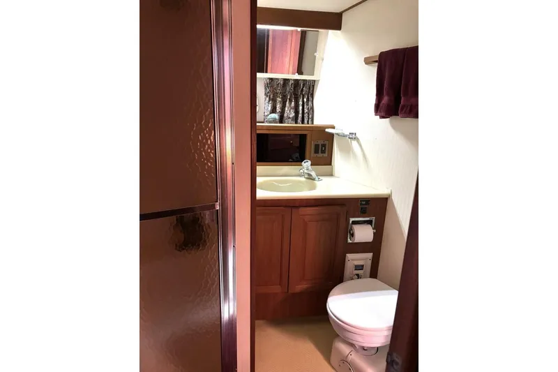Slide: The Image of Bathroom interior of 1987 Viking 44 Motor Yacht with sink, toilet, and wooden cabinetry. - 9