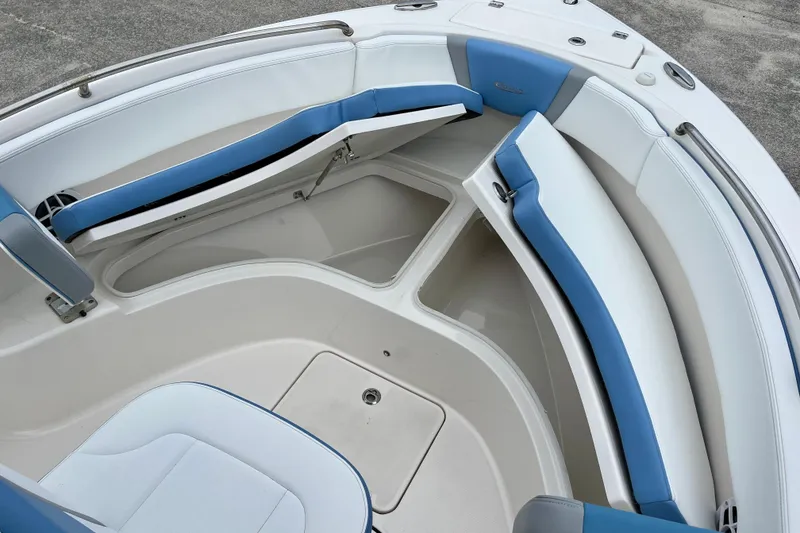 Slide: The Image of 2024 Robalo R222 Center Console boat interior with blue and white seating and storage compartments. - 14