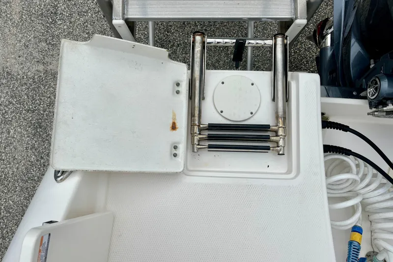 Slide: The Image of 2024 Robalo R222 Center Console boat deck with ladder and storage compartment. - 15