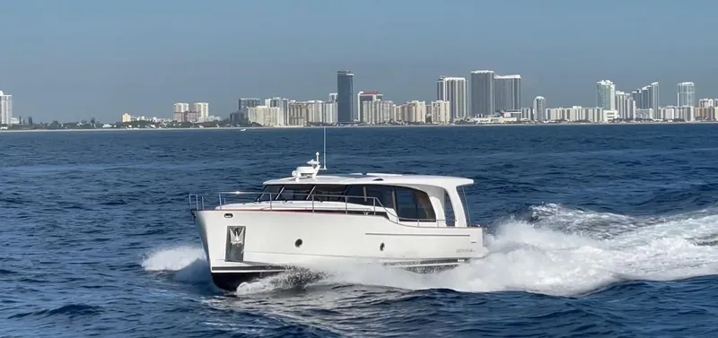 Slide: The Image of 2023 Greenline 40 yacht cruising on ocean with city skyline in background. - 0