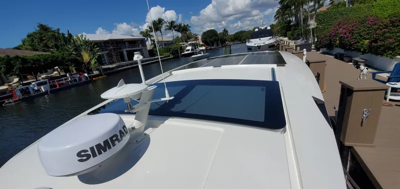 Slide: The Image of 2023 Greenline 40 yacht docked in a sunny canal, featuring solar panels and navigation equipment. - 12
