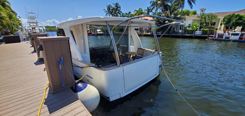 Slide: The Image of 2023 Greenline 40 yacht docked by a sunny waterfront with palm trees. - 14
