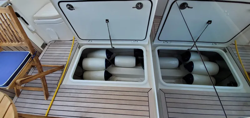 Slide: The Image of 2023 Greenline 40 yacht deck with open storage compartments and wooden chair. - 21