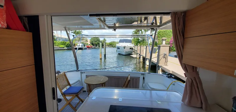 Slide: The Image of Interior view of 2023 Greenline 40 yacht with open deck and marina backdrop. - 24