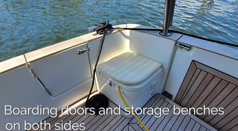 Slide: The Image of 2023 Greenline 40 yacht with boarding doors and storage benches, docked on calm water. - 26