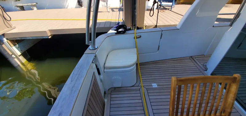 Slide: The Image of 2023 Greenline 40 yacht interior with wooden deck and seating by the dock. - 28