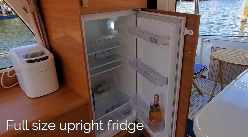 Slide: The Image of Full-size upright fridge in 2023 Greenline 40 yacht interior, with open door and visible contents. - 38