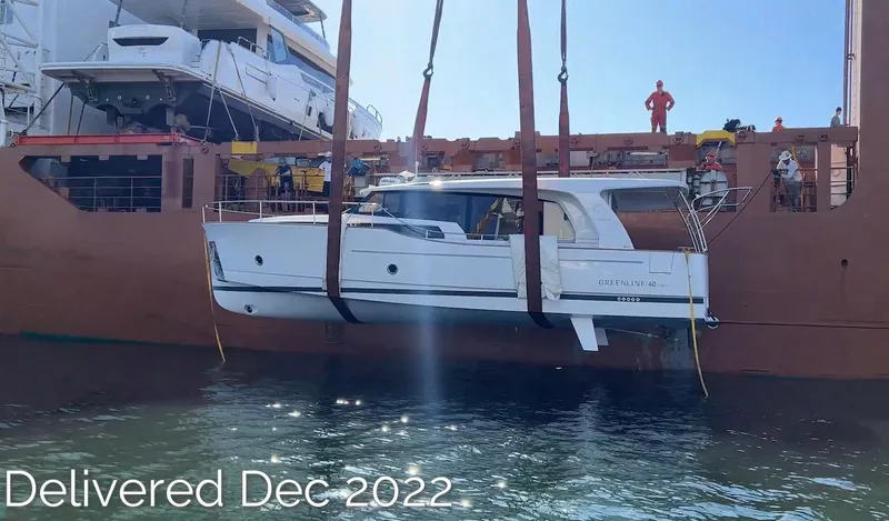 Slide: The Image of 2023 Greenline 40 yacht being delivered, December 2022, lifted by crane over water. - 4