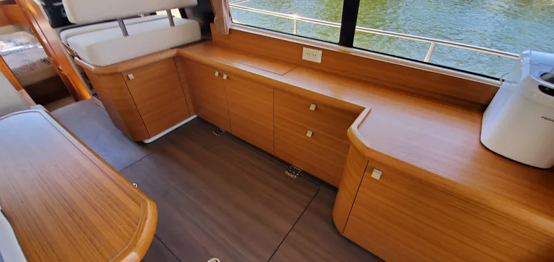 Slide: The Image of Interior of 2023 Greenline 40 yacht with wooden cabinetry and river view. - 41