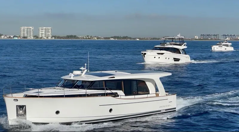 Slide: The Image of 2023 Greenline 40 yacht cruising on blue ocean with city skyline in background. - 5