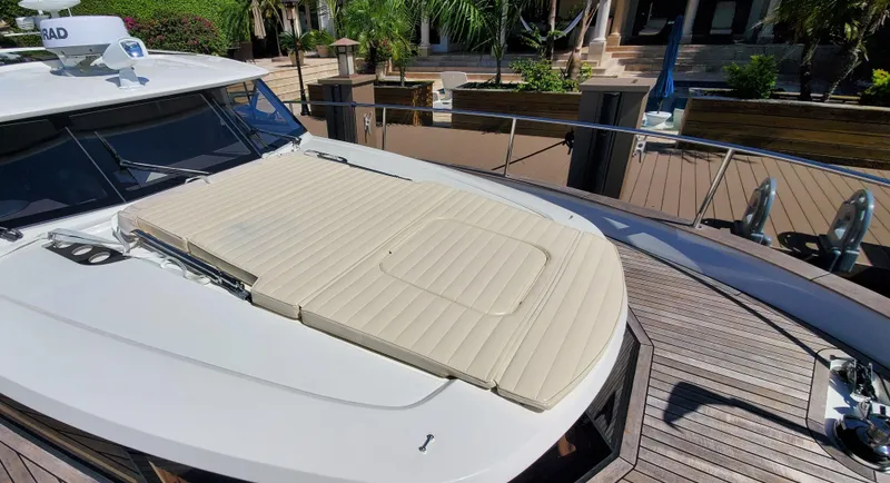 Slide: The Image of 2023 Greenline 40 yacht with sunpad on deck, docked near lush greenery. - 6